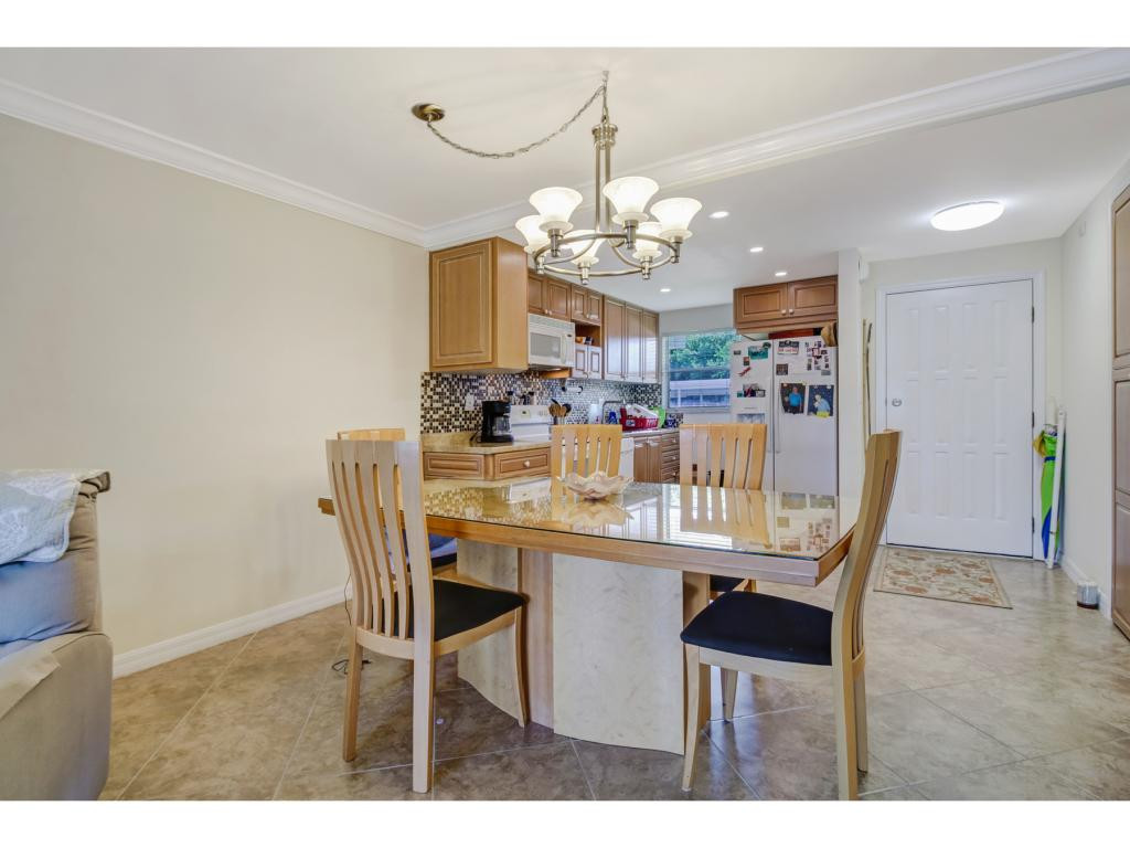 49 High Point Circle South, Unit 102 Naples, FL 34103 - Photo 11 of 31 a dining room with furniture a chandelier and kitchen view