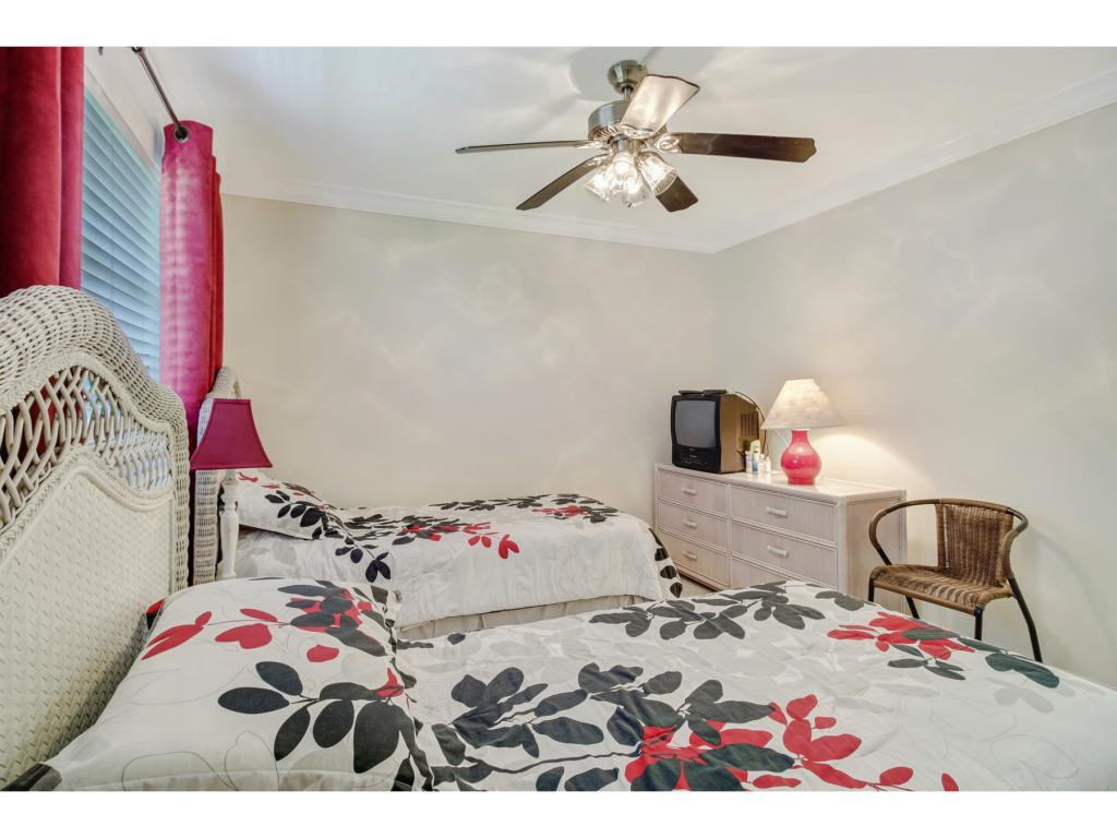 49 High Point Circle South, Unit 102 Naples, FL 34103 - Photo 16 of 31 a bedroom with a bed and a dresser