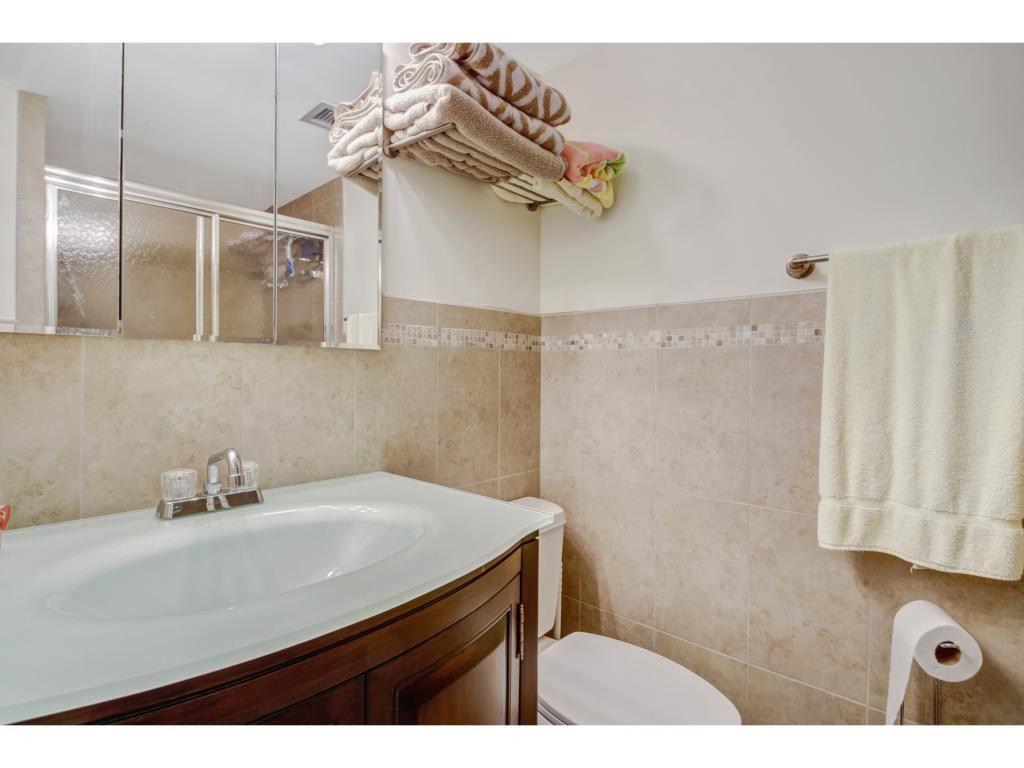 49 High Point Circle South, Unit 102 Naples, FL 34103 - Photo 17 of 31 a bathroom with a sink and mirror
