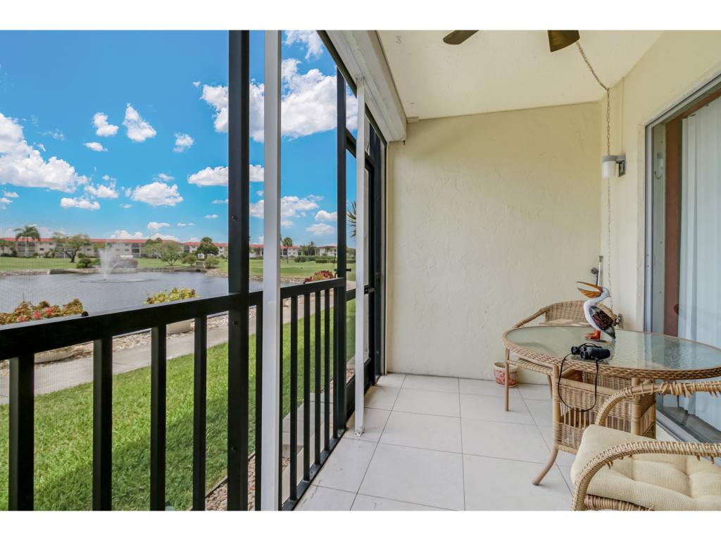 49 High Point Circle South, Unit 102 Naples, FL 34103 - Photo 24 of 31 a view of a balcony with chair and the glass door