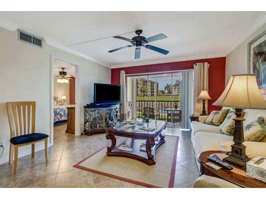 49 High Point Circle South, Unit 102 Naples, FL 34103 - Photo 7 of 31 a living room with furniture and a flat screen tv