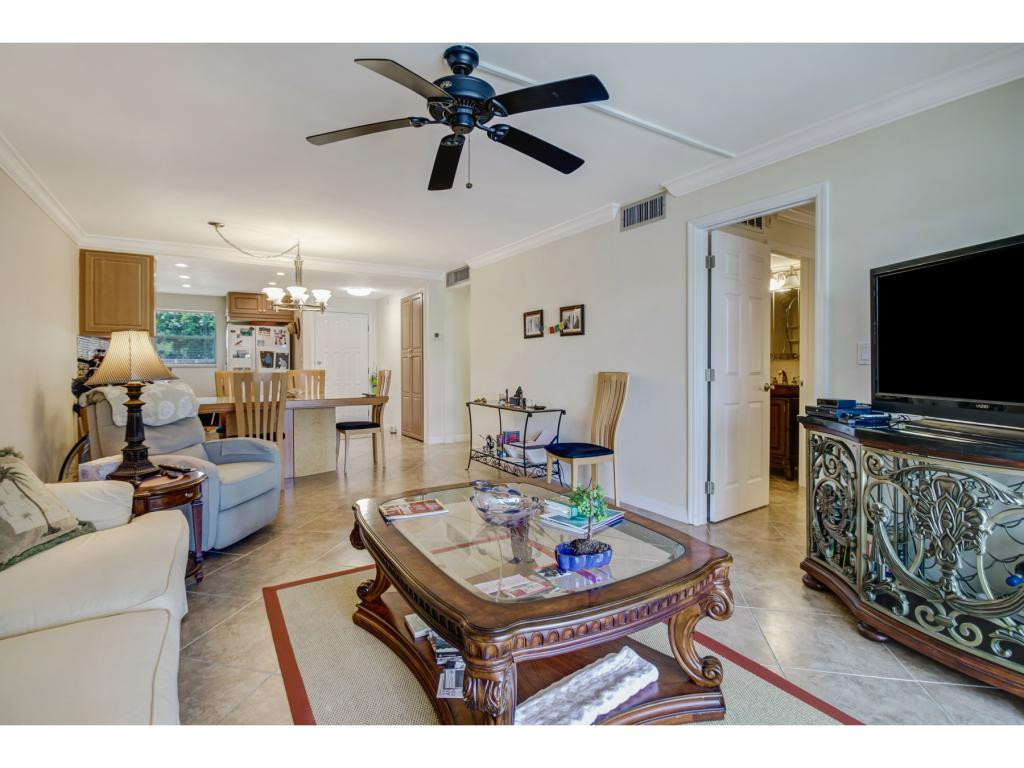 49 High Point Circle South, Unit 102 Naples, FL 34103 - Photo 9 of 31 a living room with furniture and a flat screen tv
