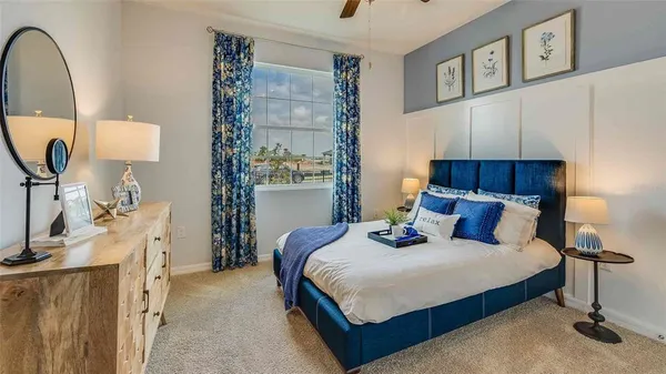 a bedroom with a bed a mirror and lamp