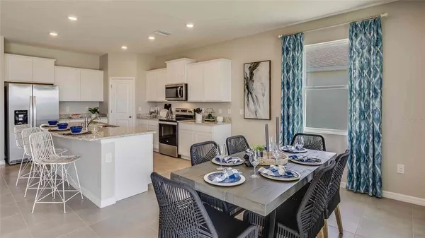 a kitchen with a dining table chairs and refrigerator