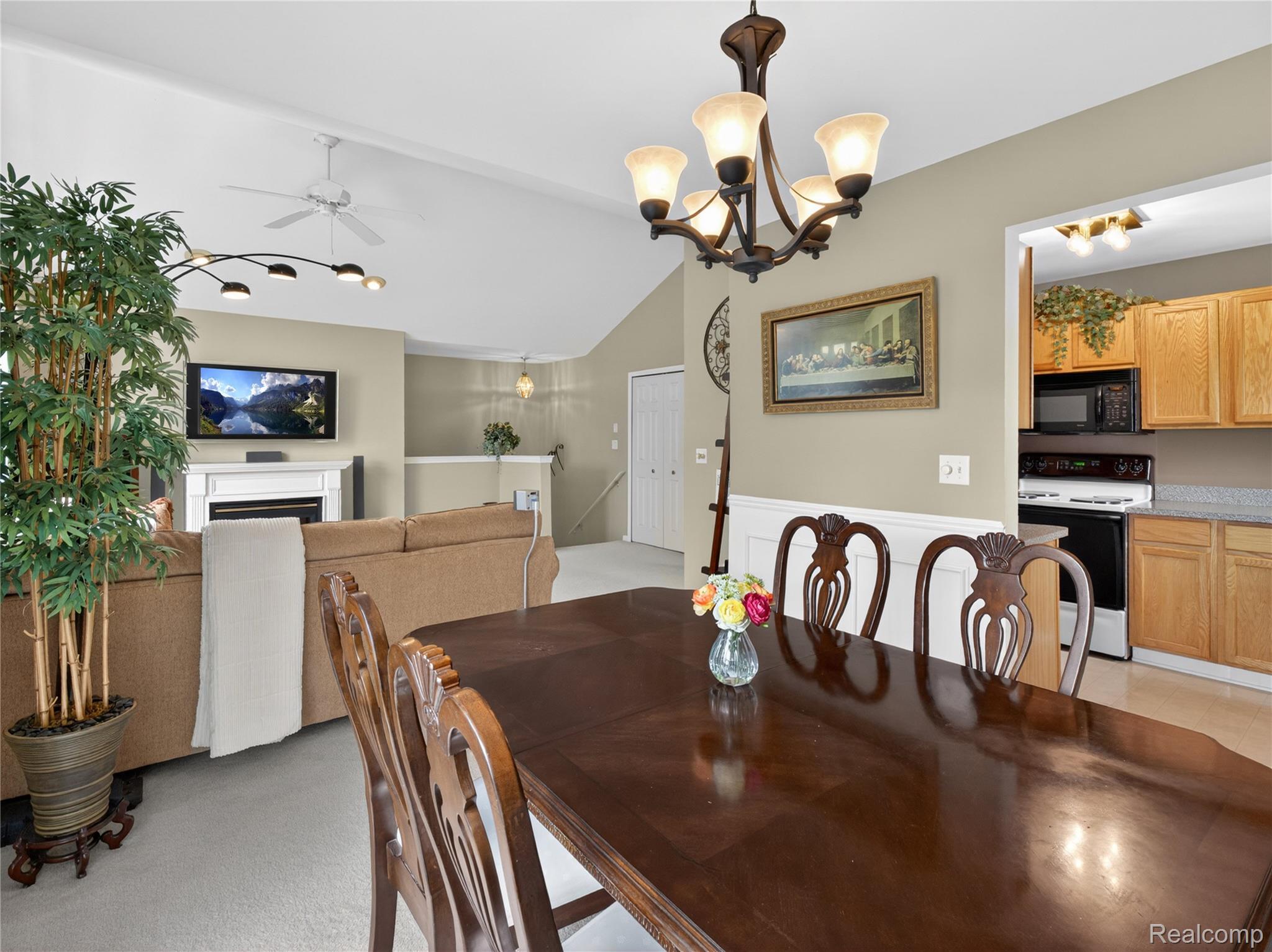 1834 Flagstone Circle, Unit 37 Rochester, MI 48307 - Photo 12 of 31 Dining space featuring a ceiling fan, a fireplace, hanging lights, and vaulted ceiling