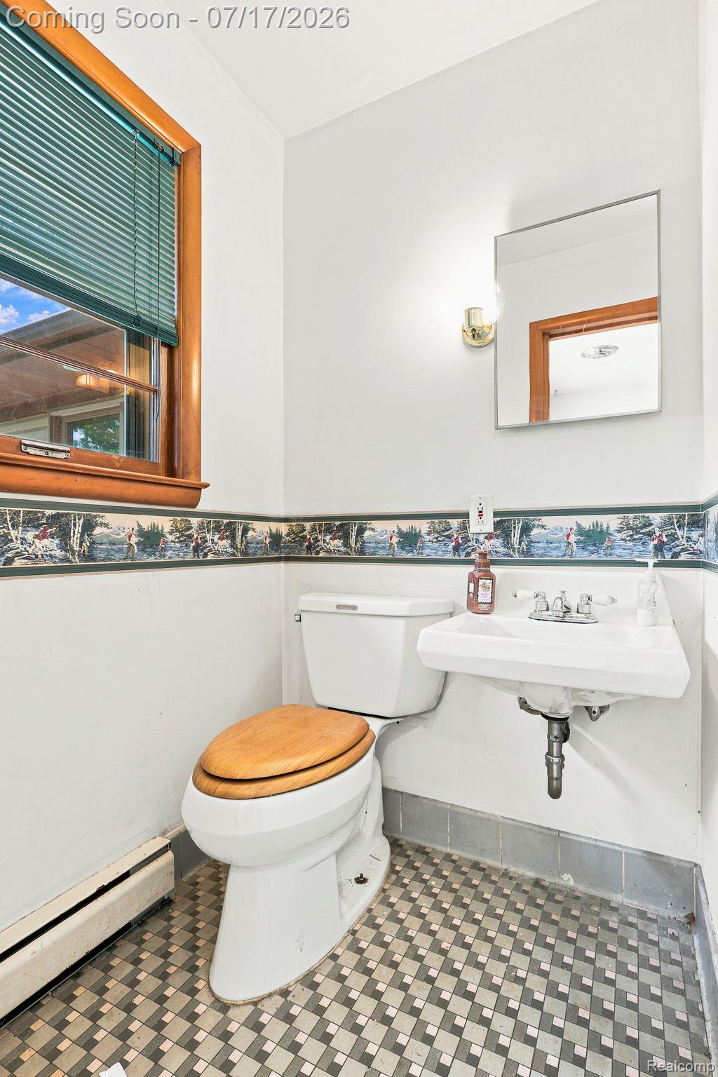 9805 Dolan Road Columbus, MI 48063 - Photo 9 of 39 Compact bathroom featuring a wall-mounted sink, a toilet with a wood-finish seat, and patterned floor tiling