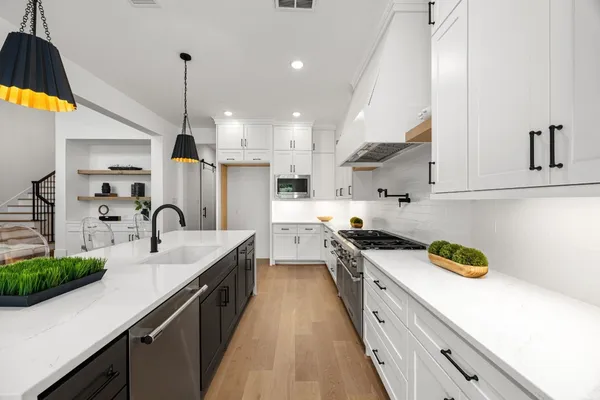 a kitchen with kitchen island granite countertop a sink a counter space appliances and cabinets