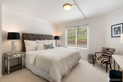a bedroom with a bed and a view of a flat screen tv