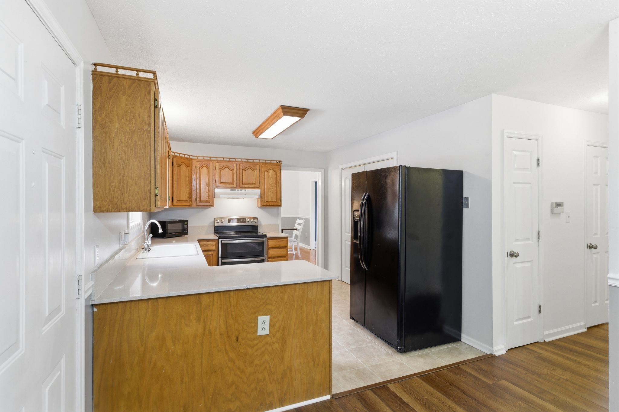 615 Vaughan's Gap Road Spring Hill, TN 37174 - Photo 7 of 26 a kitchen with stainless steel appliances granite countertop a refrigerator a stove and a sink with wooden floor