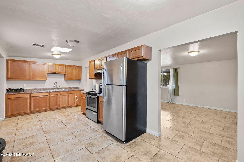 1301 West Kleindale Road Tucson, AZ 85705 - Photo 11 of 27 a kitchen with stainless steel appliances granite countertop a refrigerator and a stove top oven