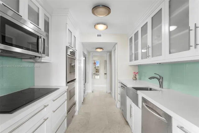 a kitchen with stainless steel appliances granite countertop a sink and dishwasher a stove top oven with wooden floor