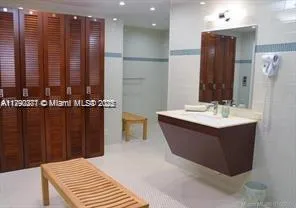a bathroom with a bathtub sink vanity and mirror