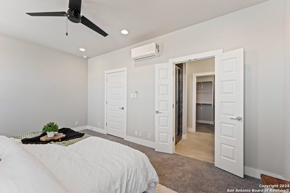 7942 Kennedy Hill Drive, Unit 8 San Antonio, TX 78235 - Photo 17 of 35 a bedroom with a bed and a walk in closet