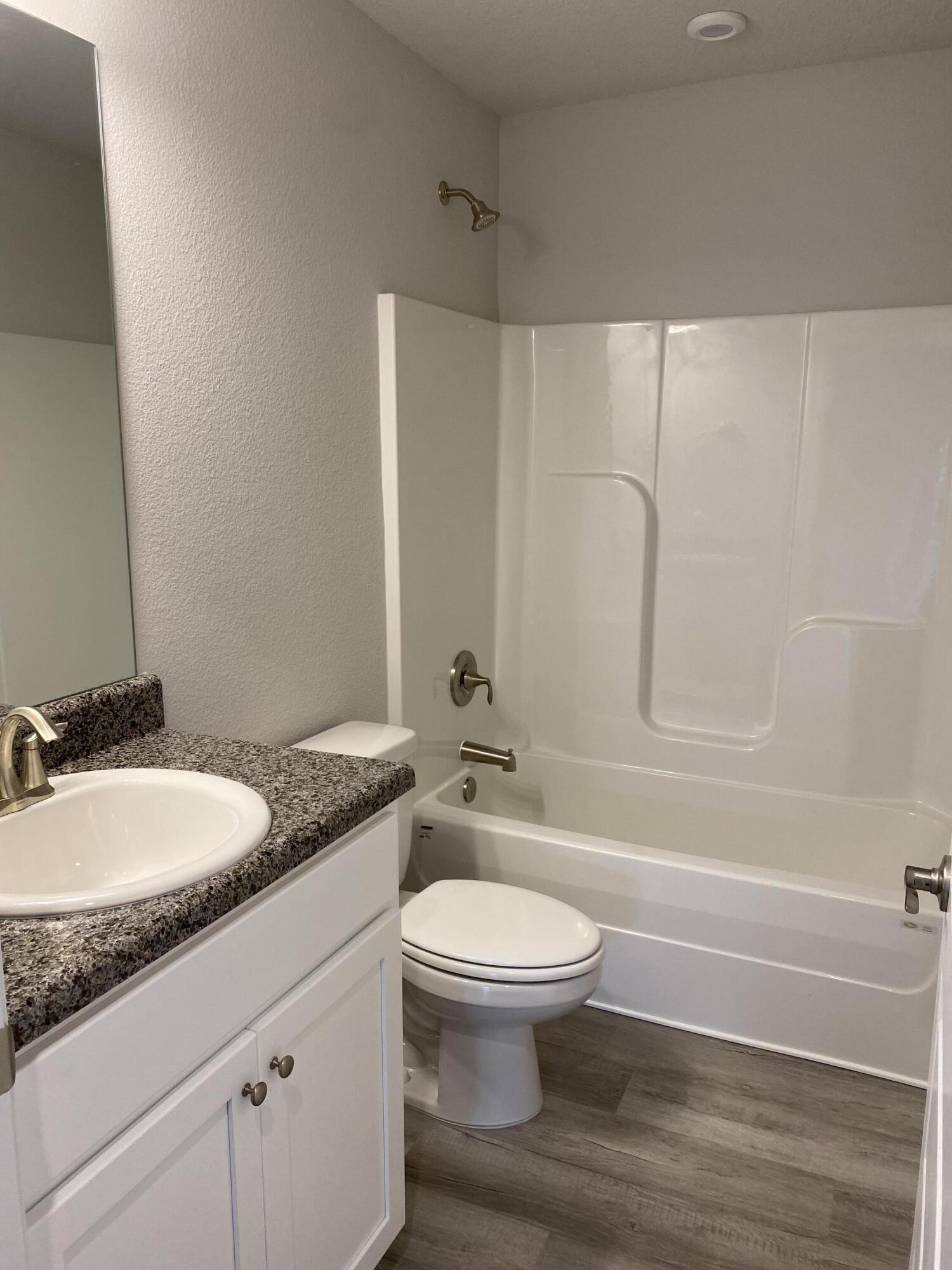 326 Keswick Lane Crestview, FL 32536 - Photo 19 of 22 a bathroom with a granite countertop toilet a sink and a bathtub