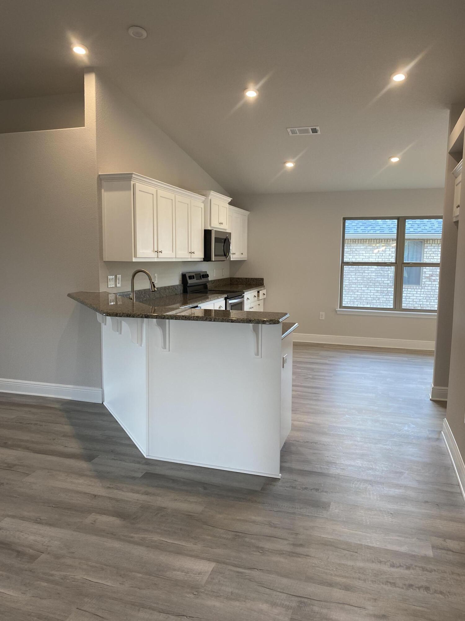 326 Keswick Lane Crestview, FL 32536 - Photo 10 of 22 a kitchen with stainless steel appliances granite countertop a sink a stove and a wooden floors