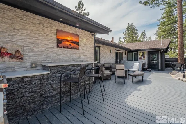 a backyard of a house with wooden floor outdoor seating and yard in the back