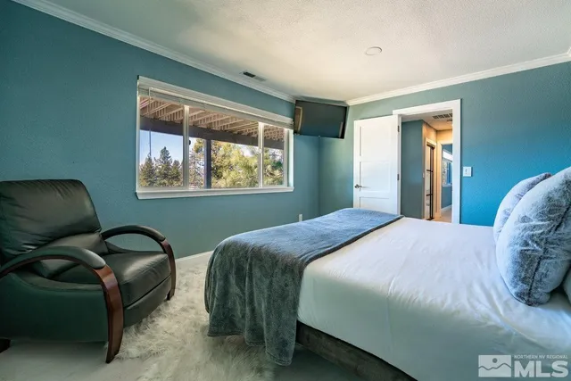 a bedroom with a bed chair and window