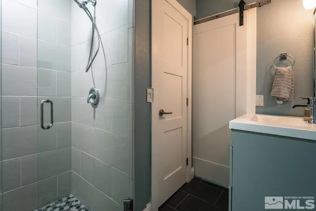 a bathroom with a shower sink and mirror