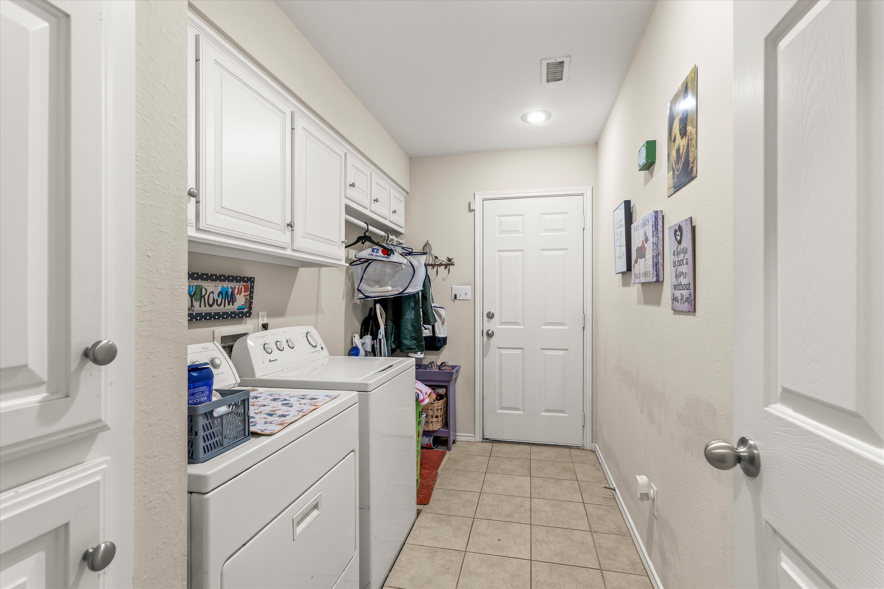 710 Poplar Street Levelland, TX 79336 - Photo 17 of 23 a utility room with cabinets washer and dryer