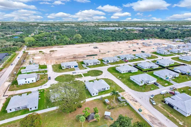a kitchen with a sink dishwasher and white cabinets with wooden floor