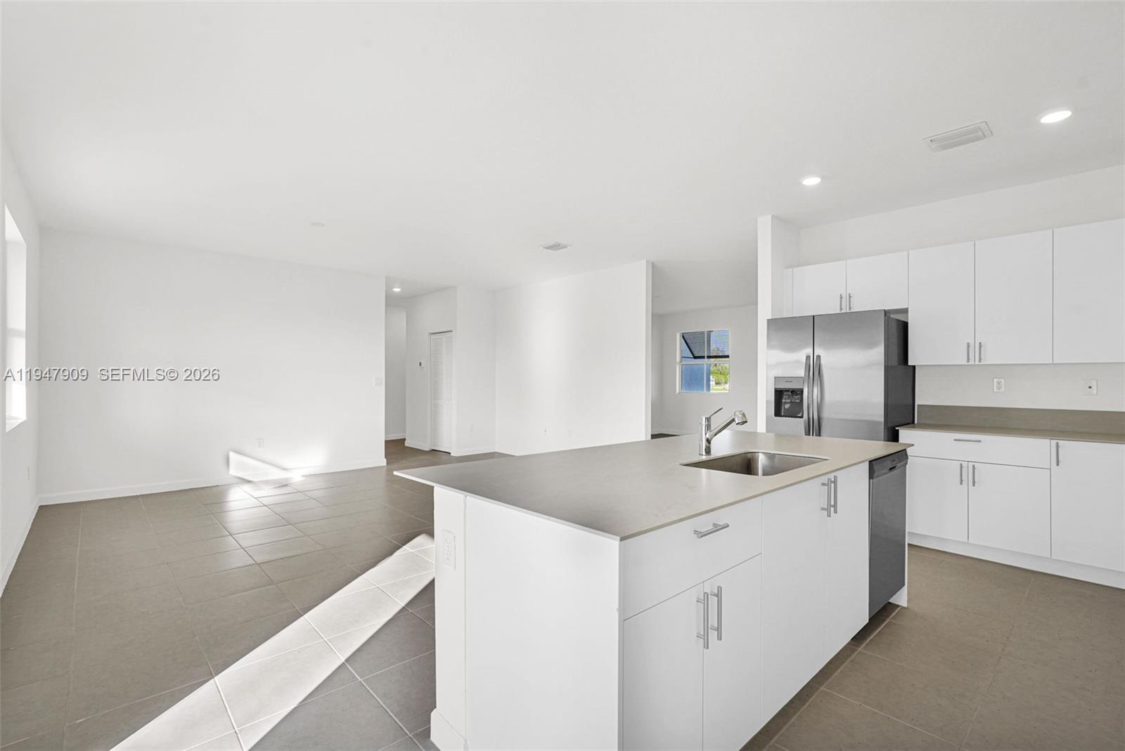 27254 Southwest 159th Path Homestead, FL 33031 - Photo 55 of 100 a kitchen with a sink dishwasher and white cabinets with wooden floor