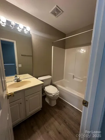 a bathroom with a double vanity sink toilet mirror and bathtub