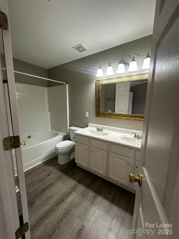 a bathroom with a double vanity sink toilet and mirror