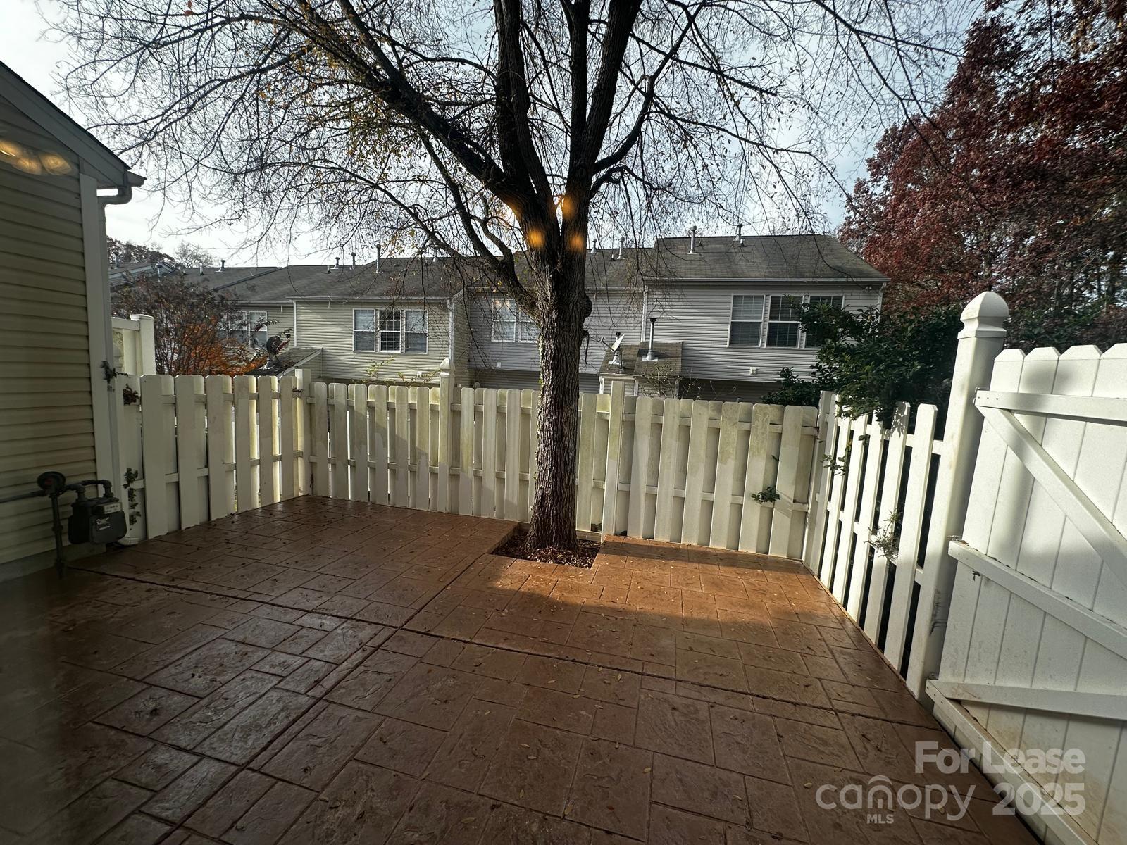 6828 Rothchild Drive Charlotte, NC 28270 - Photo 28 of 29 a view of a white house with a large tree and wooden fence