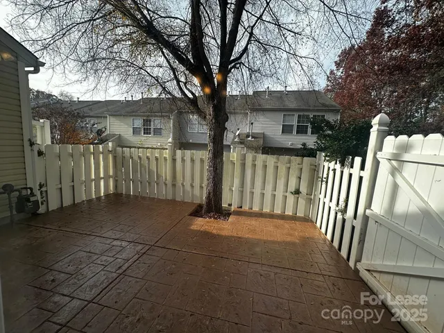 a view of a house with a small yard and a large tree
