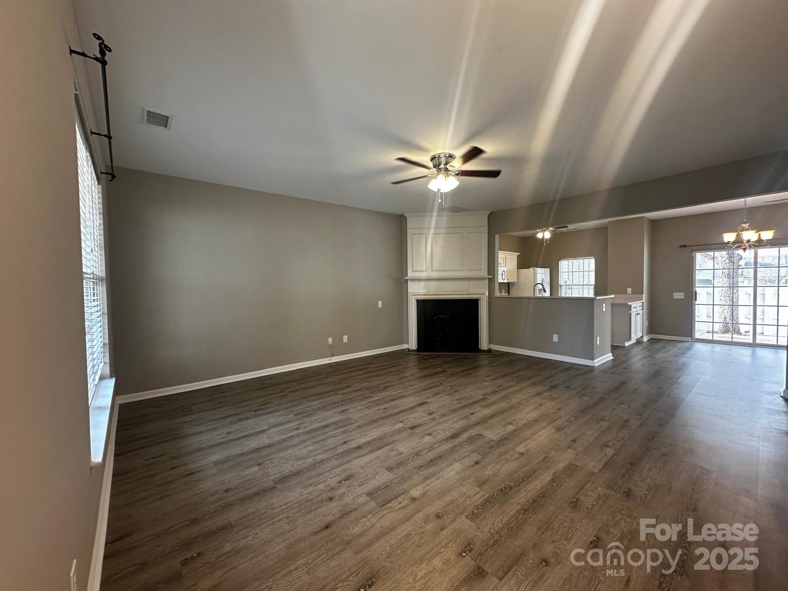 6828 Rothchild Drive Charlotte, NC 28270 - Photo 4 of 29 an empty room with wooden floor chandelier fan and windows