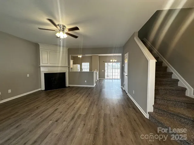 a view of a livingroom with wooden floor and staircase