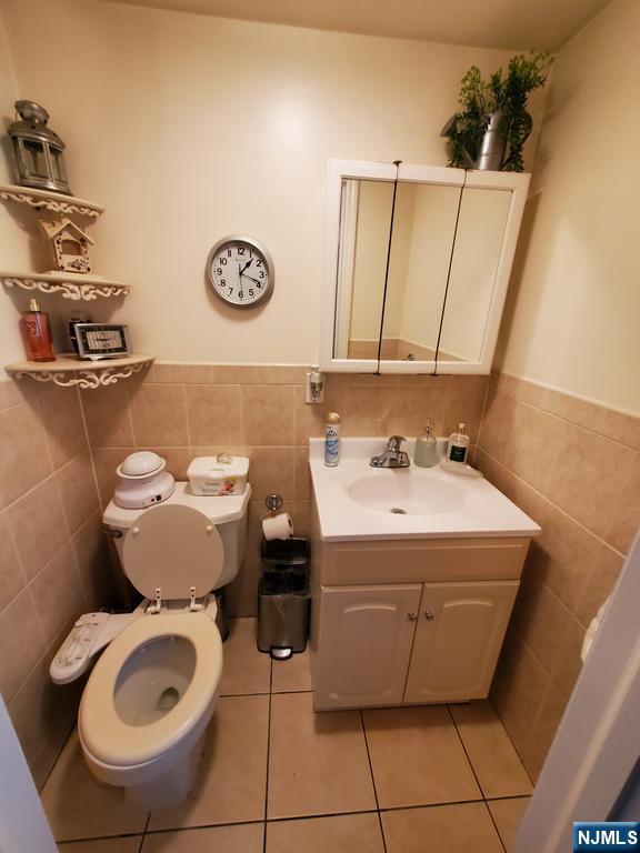 439 North 8th Street Fairview, NJ 07022 - Photo 13 of 20 a bathroom with a sink mirror vanity and toilet