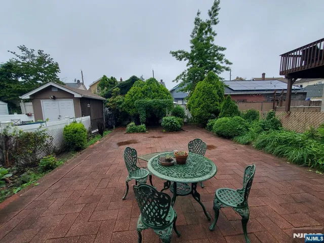 a backyard of a house with table and chairs plants