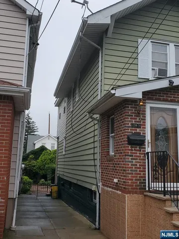 a view of a house with a door and wooden bench