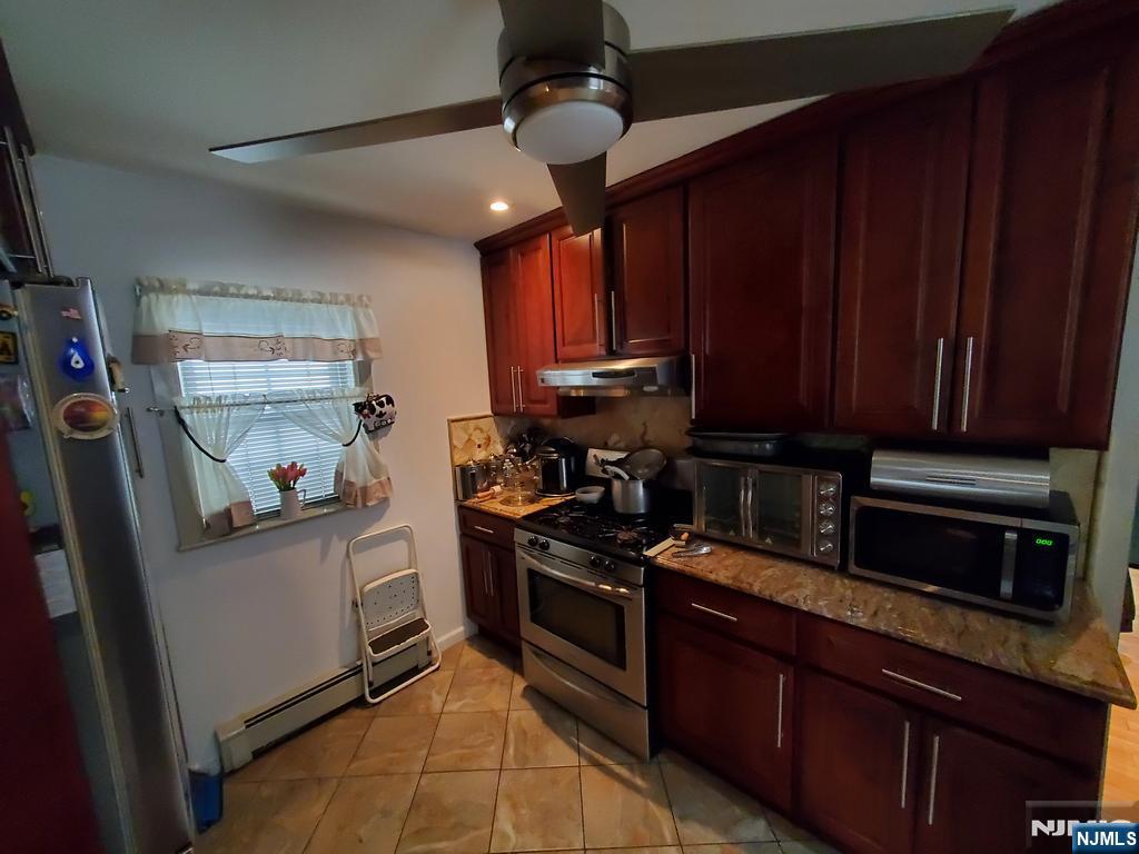 439 North 8th Street Fairview, NJ 07022 - Photo 9 of 20 a kitchen with stainless steel appliances granite countertop wooden cabinets a stove top oven a sink and dishwasher