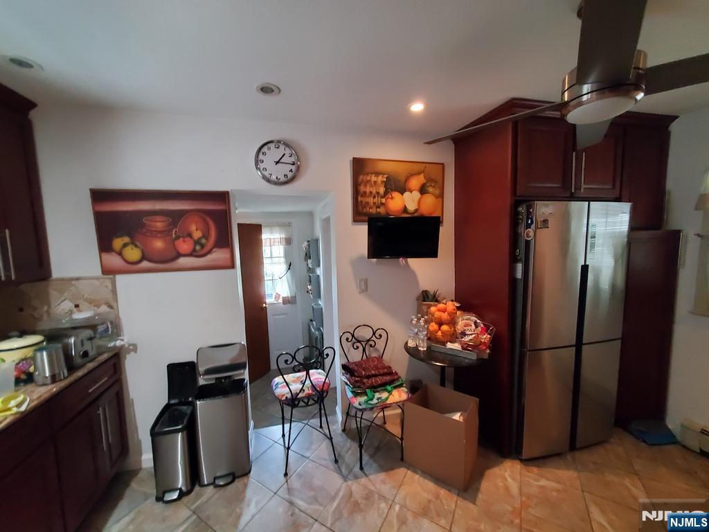439 North 8th Street Fairview, NJ 07022 - Photo 10 of 20 a living room with furniture a flat screen tv and a refrigerator