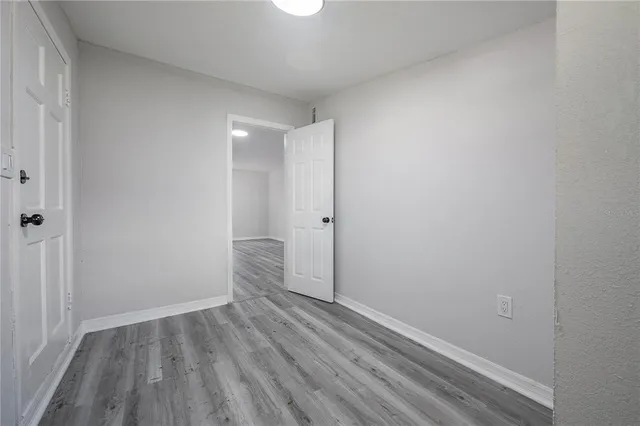 a view of an empty room with wooden floor
