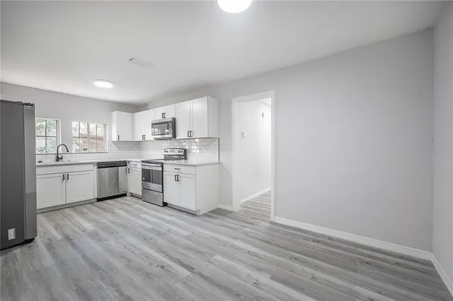 a kitchen with a sink cabinets and wooden floor