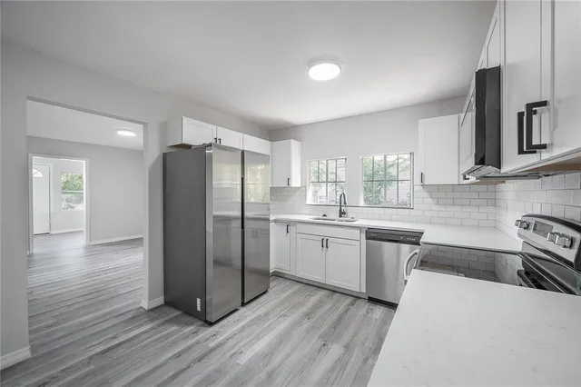 a kitchen with stainless steel appliances a refrigerator sink and cabinets