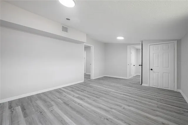 a view of an empty room with wooden floor