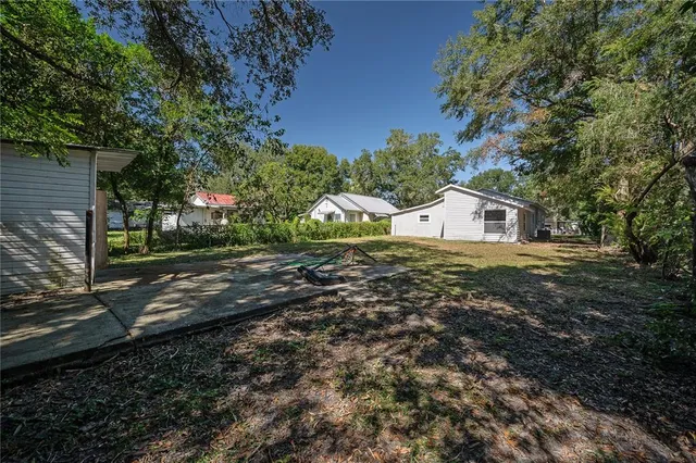 a view of a house with a yard and tree