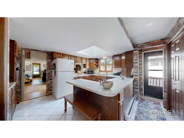 a kitchen with stainless steel appliances granite countertop a refrigerator a sink dishwasher a oven with wooden cabinets and countertops