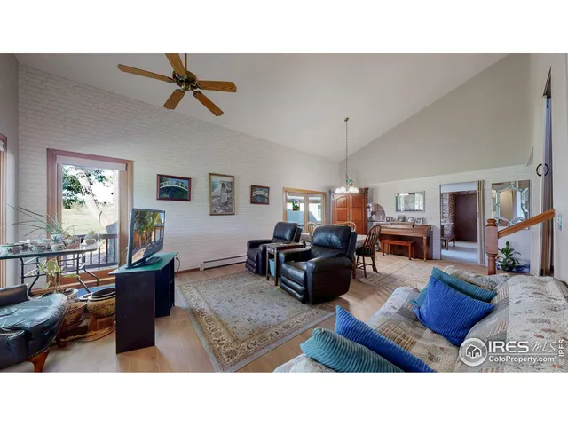 a living room with furniture a chandelier and a dining table