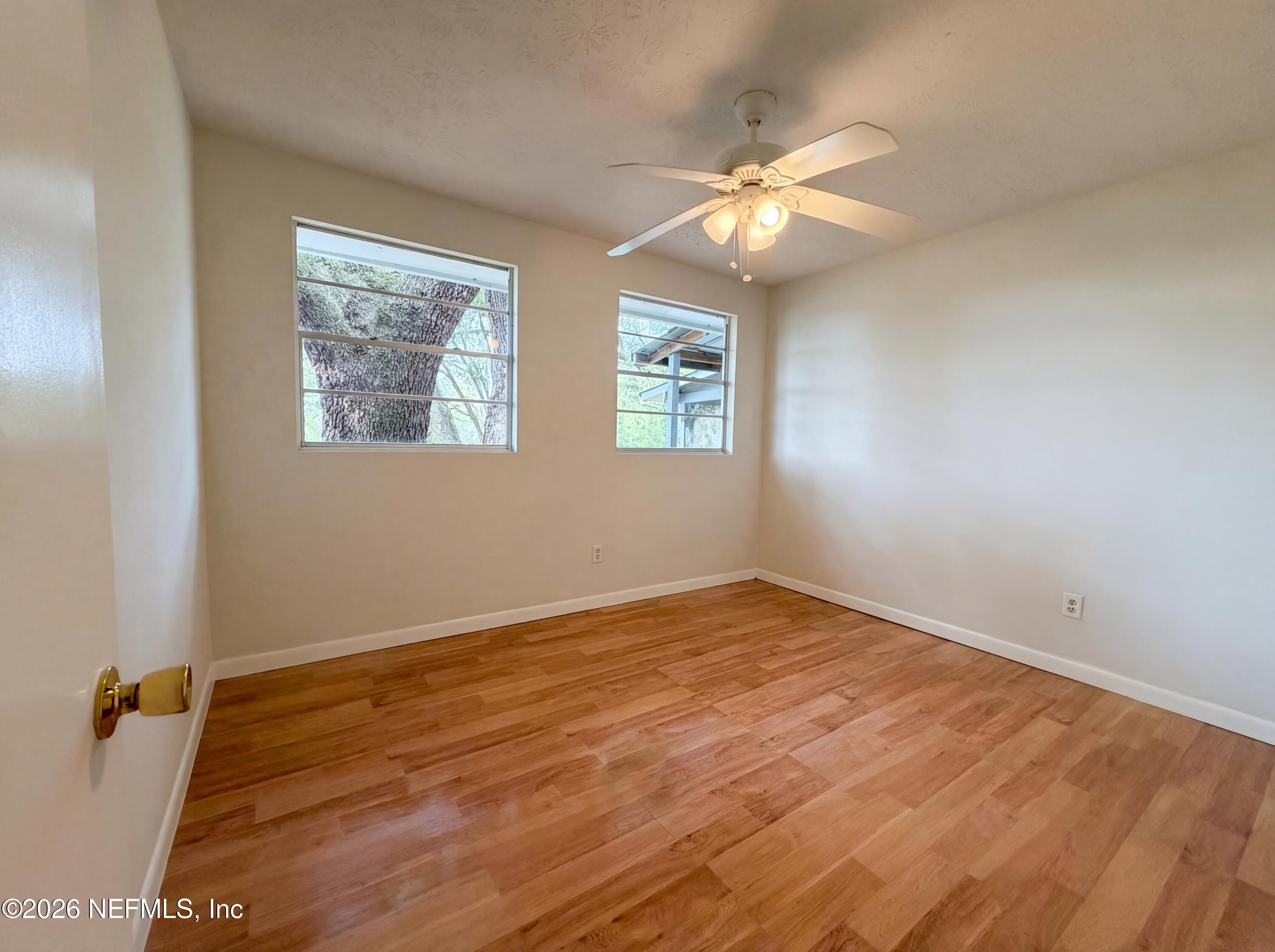6917 Gatorbone Road Keystone Heights, FL 32656 - Photo 19 of 24 a view of an empty room with wooden floor and a window