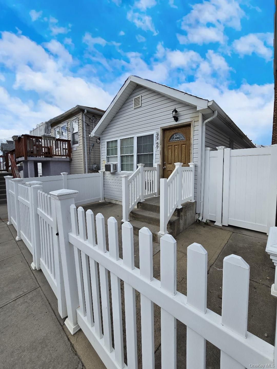 View of front of property featuring a fenced front yard and a gate