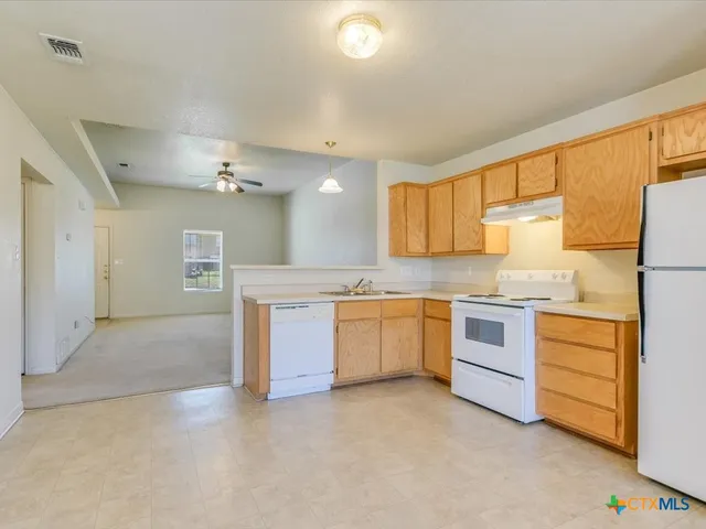 a large white kitchen with granite countertop a sink