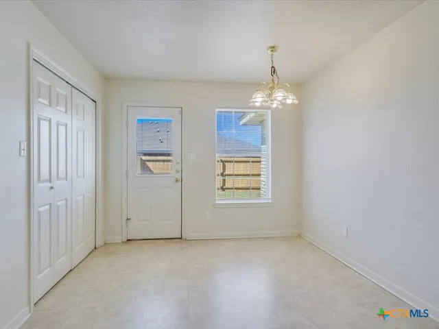 an empty room with windows and entrance