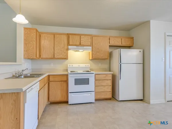 a kitchen with a stove top oven and refrigerator