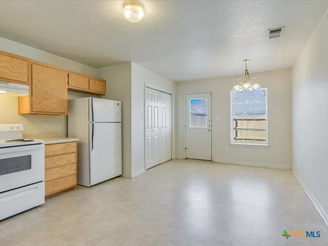 a view of a kitchen with refrigerator and cabinet