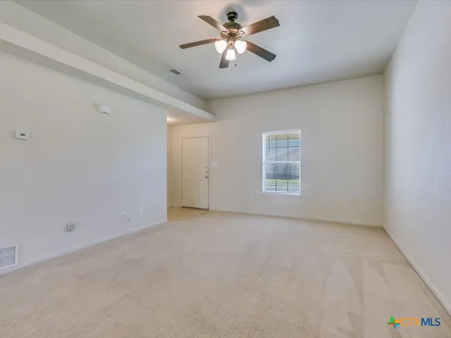 a view of room with a ceiling fan and window